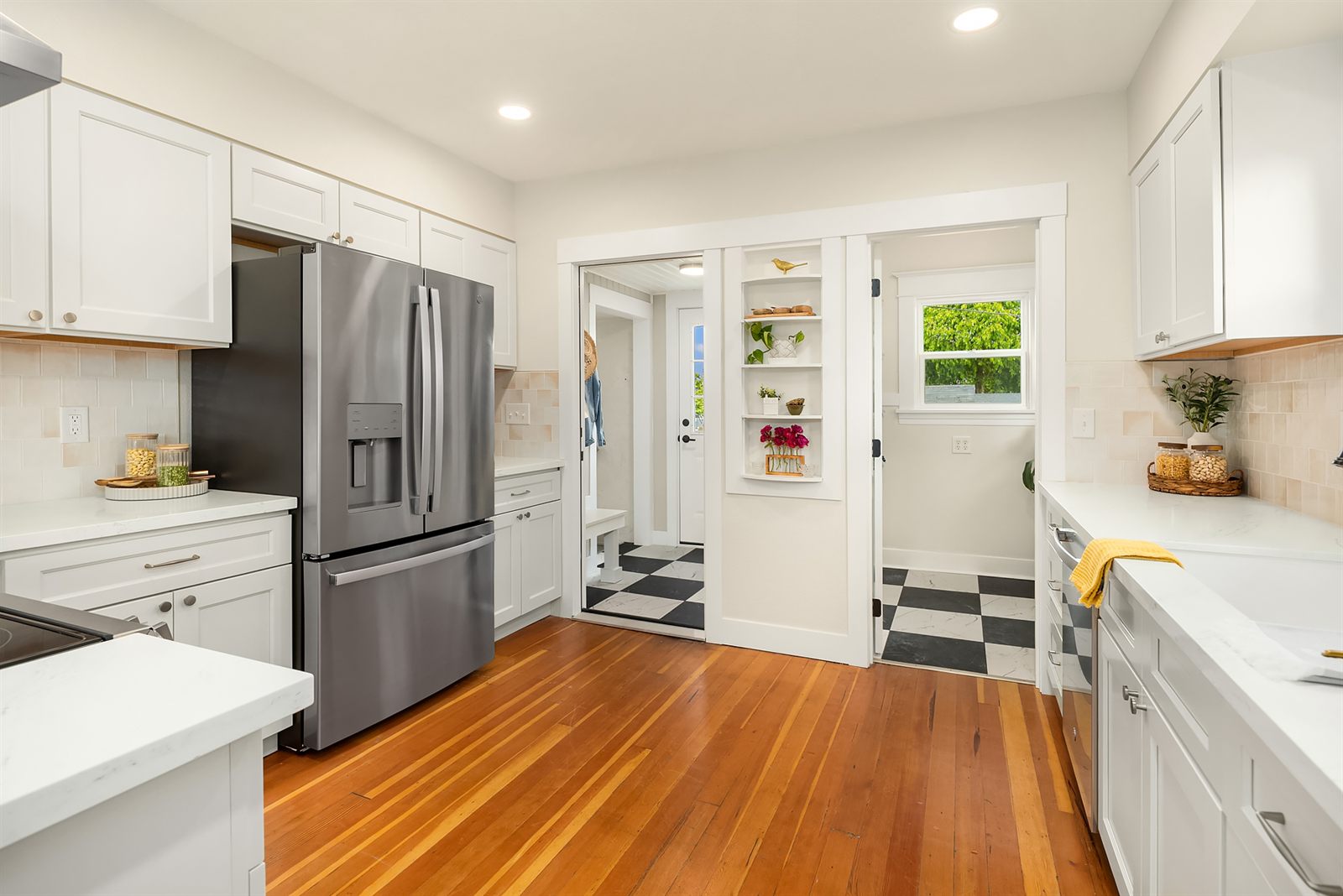 A fully renovated white rental kitchen with hardwood floors